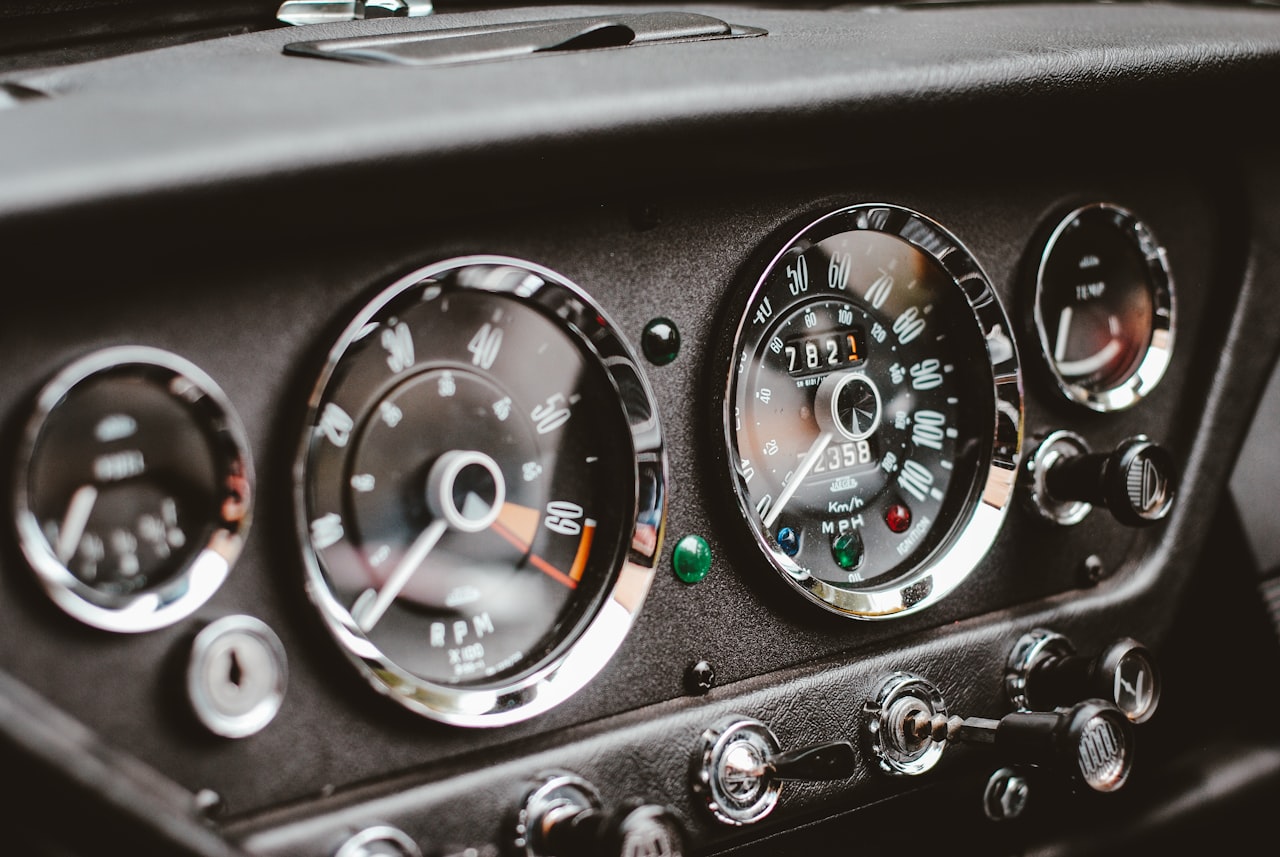Close-up of vintage car instrument panel cluster showing classic gauges and wiring
