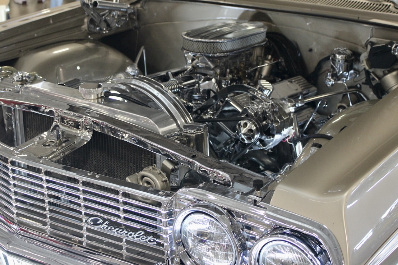 Show-quality chrome engine bay on a classic Chevrolet, with polished intake, valve covers, and radiator surround