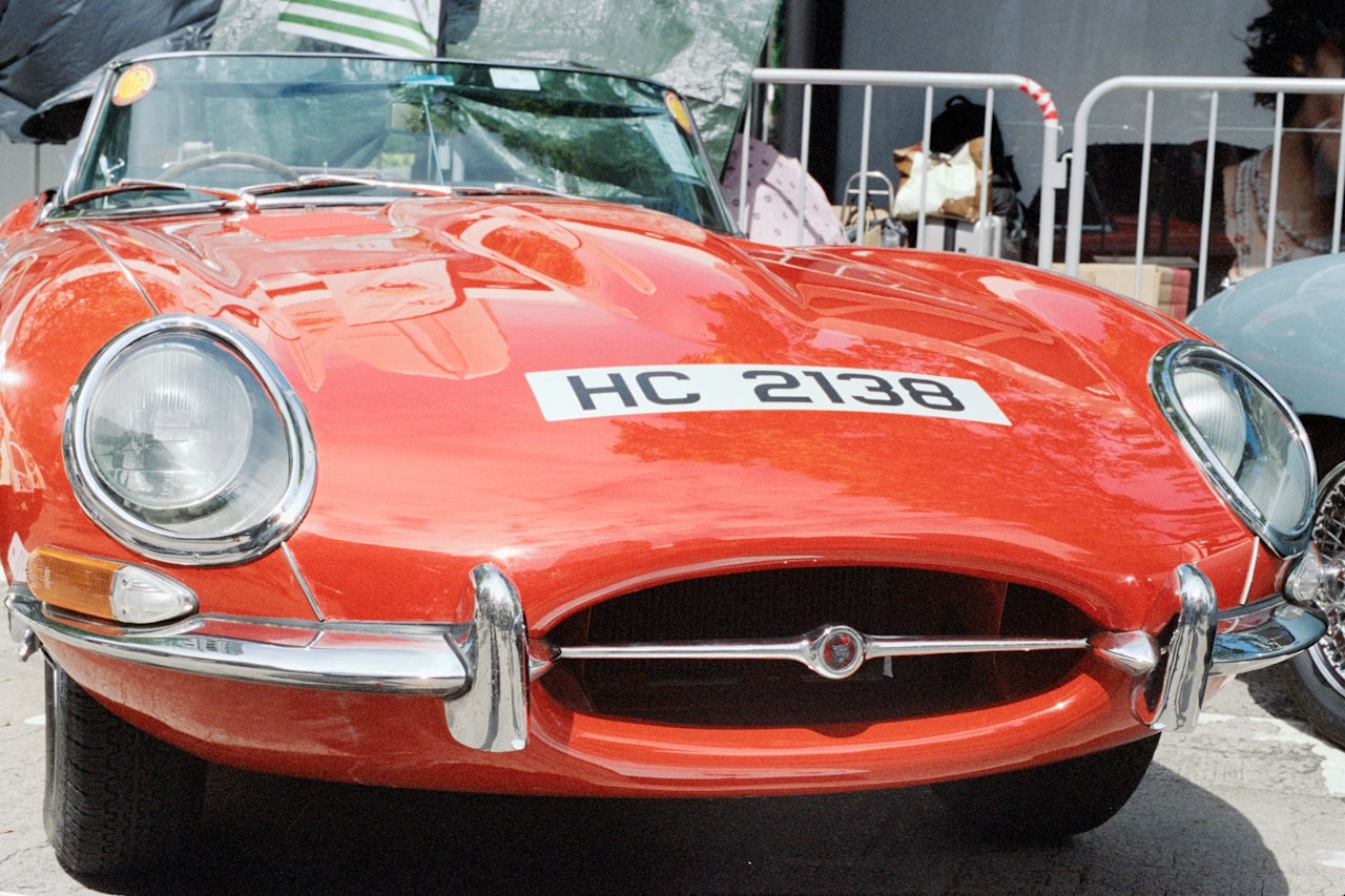 Red Jaguar E-Type classic sports car with distinctive long bonnet and wire wheels