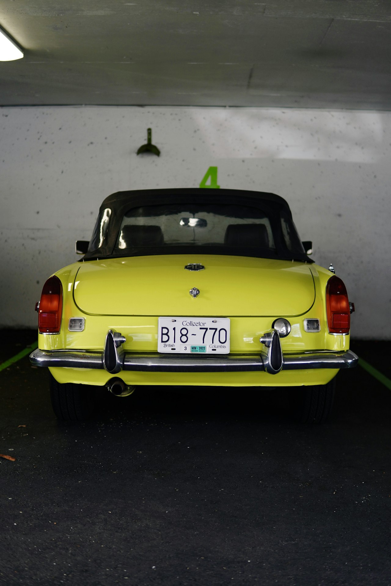 Yellow MGB sports car in a classic car setting