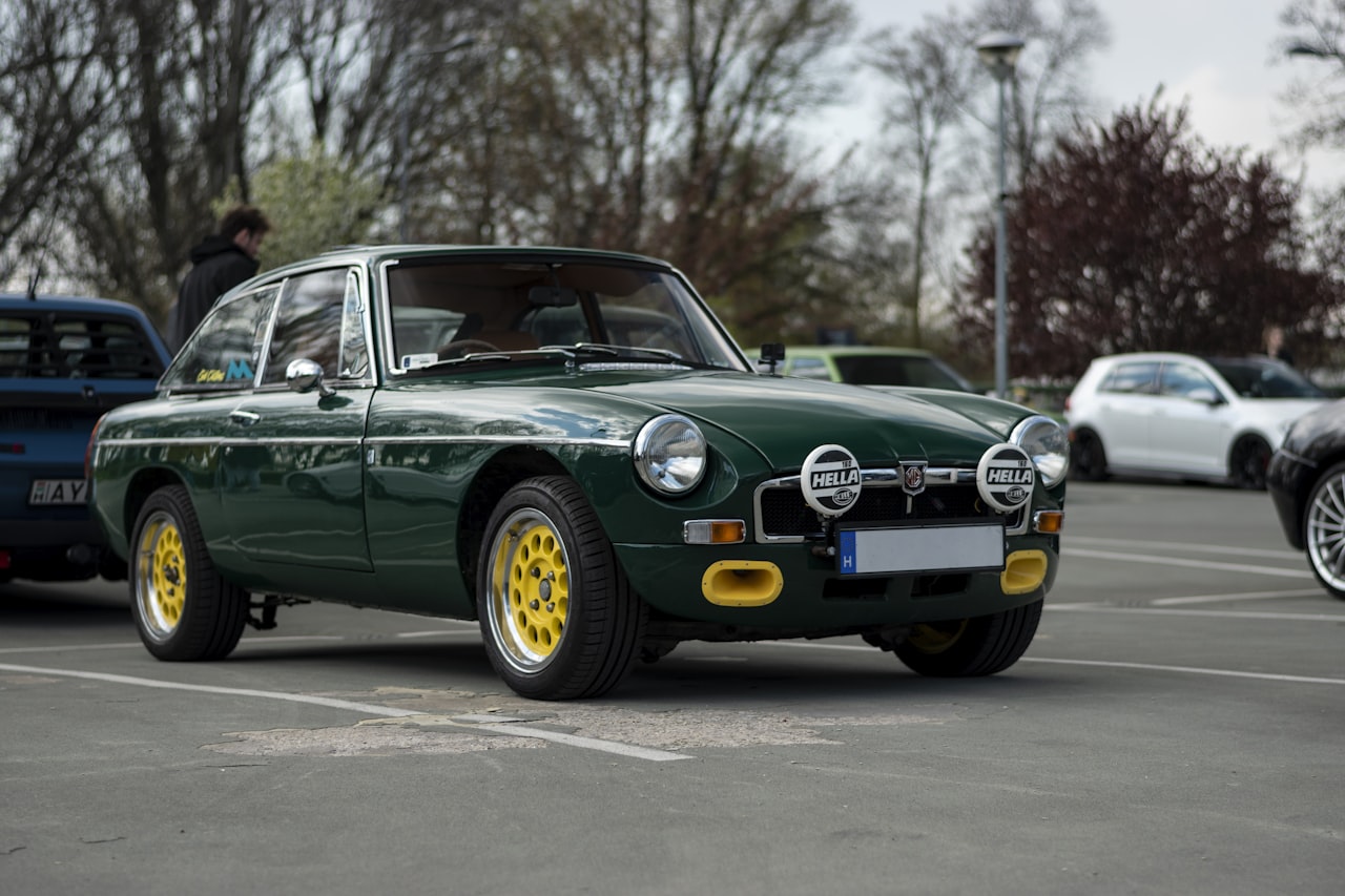 Green MGB sports car parked in a classic car setting